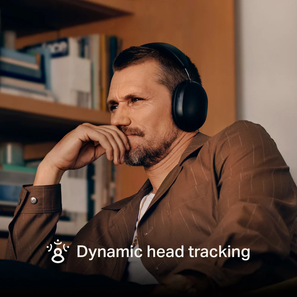 A man wearing Sonos Ace headphones, sitting in a library. The text 